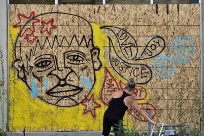 Una manifestante fue registrada por pintar un mural.