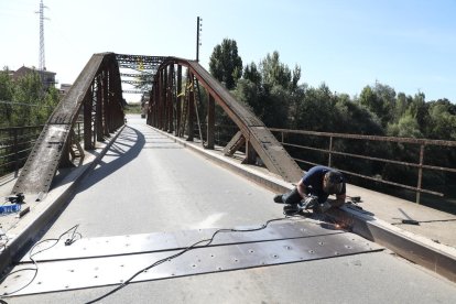 Uno de los operarios trabajó ayer en fijar las nuevas chapas en el firme del puente. 