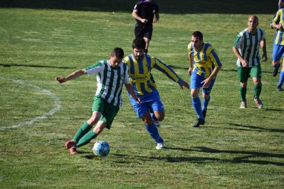 Un jugador del Alguaire controla el esférico pese a la presión rival.