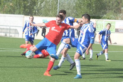 Un jugador del Juneda trata de rematar ante la oposición de un adversario.