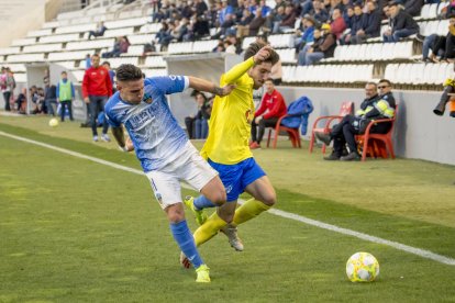 Raúl González lluita per la pilota a la banda amb un futbolista de l’Eixea.