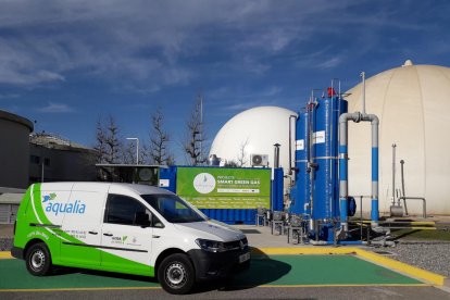 La màquina que crea el biocombustible amb el gas del llot al costat d’un vehicle que funciona gràcies a ell.