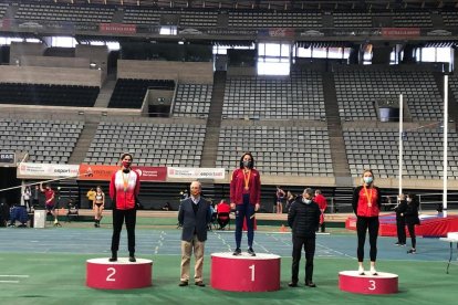 Elena Llobera, a la izquierda, en el podio de salto de longitud.