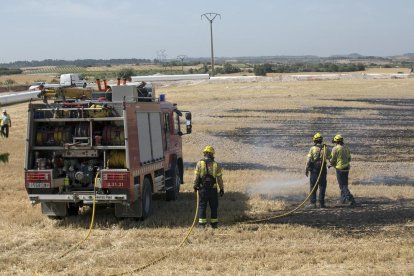 Los Bomberos trabajando ayer al mediodía en la extinción del fuego de Verdú. 