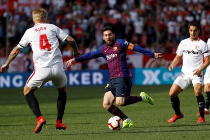 Leo Messi, capità dels blaugranes i autor de tres dels quatre gols davant del Sevilla, prova de driblar el defensa local Simon Kjaer.