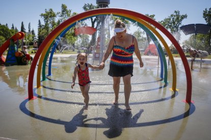 Una madre y su hija intentan sofocar las altas temperaturas bañándose en una fuente en Canadá.