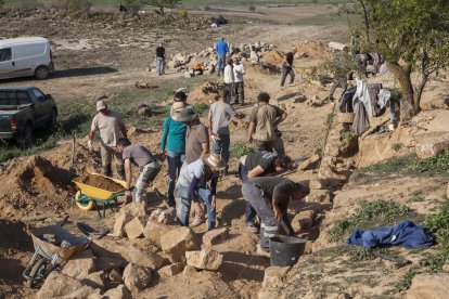 Voluntarios trabajando ayer en la conservación de márgenes de piedra seca en Castellserà.