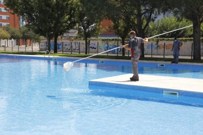 Operarios efectuando ayer tareas de limpieza en las piscinas municipales de Balàfia.