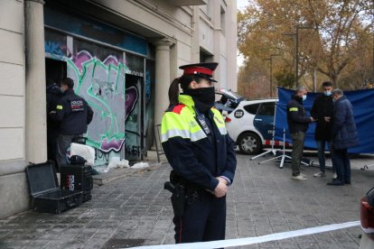 Una agente de los Mossos frente al local okupado donde murieron la pareja y sus hijos de 1 y 3 años.