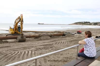 Una dona observant els treballs de regeneració de la platja de la Pineda (Vila-seca).