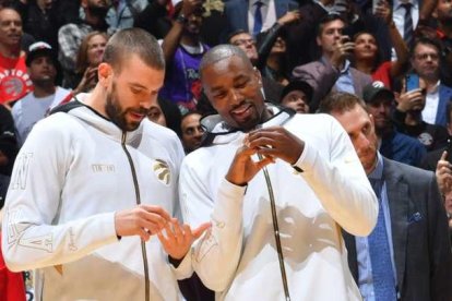 Marc Gasol y Serge Ibaka miran el anillo de campeones que les entregaron antes del partido.