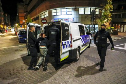 Momento que el arrestado es introducido en el vehículo policial.