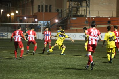 Un jugador del Tàrrega pugna por el balón ayer ante varios jugadores del Valls.