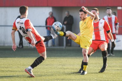 Un jugador del Almacelles pugna con un adversario por el control de un balón dividido.