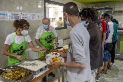 Los primeros comensales recibiendo su comida en el primer día de apertura del comedor social.