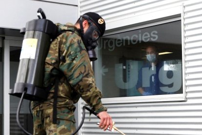 Un paciente observa la actuación de miembros del Ejercito de Tierra que trabajan desinfectando los alrededores del Hospital Trias i Pujol (Can Ruti ) de Badalona