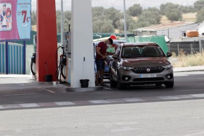 Un conductor en pleno proceso de llenar el depósito de su vehículo.