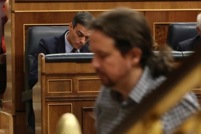 El líder de Unidas Podemos, Pablo Iglesias, pasa ante el presidente del Gobierno en funciones, Pedro Sánchez.