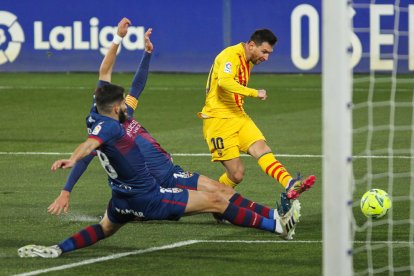 Messi remata ante dos jugadores del Huesca.