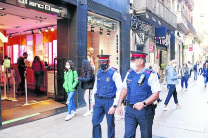 Dos mossos patrullando por el Eix Comercial. 