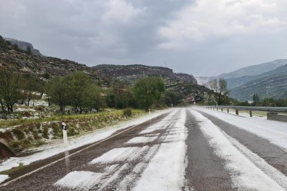 La carretera C-13, entre Pobla de Segur i Gerri de la Sal, coberta de pedra en el marc d'una tempesta d'estiu.