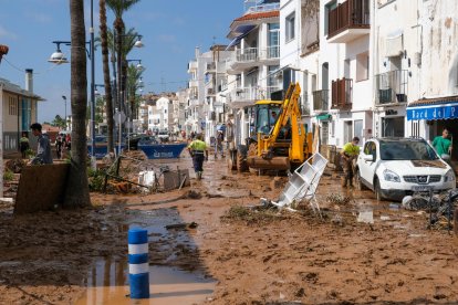 Unos vecinos de Alcanar trabajan para sacar el agua de su casa.