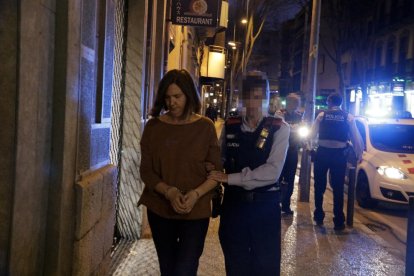 Una agente de los Mossos d’Esquadra se lleva esposada a la mujer que ha ahogado a su hija de 10 años