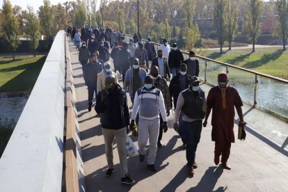 Cientos de musulmanes cruzan la pasarela tras el rezo, ayer. 