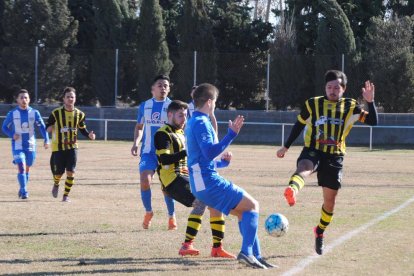 Jugadores de ambos conjuntos disputan un balón divido en un lance del partido.