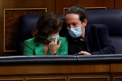 La vicepresidenta primera del Govern espanyol, Carmen Calvo, conversa amb el vicepresident segon, Pablo Iglesias, mentre assisteixen a la sessió de control al Govern, aquest dimecres al Congrés dels Diputats.