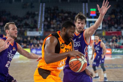 Shaquille Cleare controla la pilota davant de la presència de dos jugadors del Palència, en una acció del partit d’ahir.