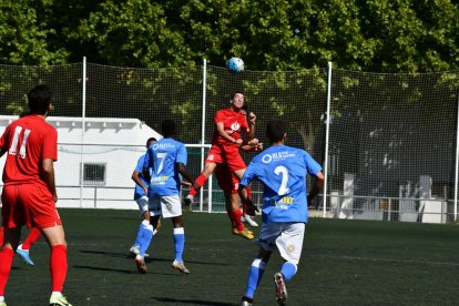 Dos jugadors de l’Alpicat rebutgen una pilota aèria durant una acció del partit.