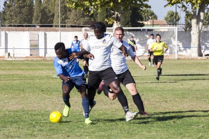 Un jugador local intenta defensar la possessió davant la pressió de diversos contraris.