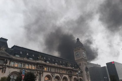 El denso humo del incendio llegó a cubrir el reloj de la céntrica estación de Lyon de París.