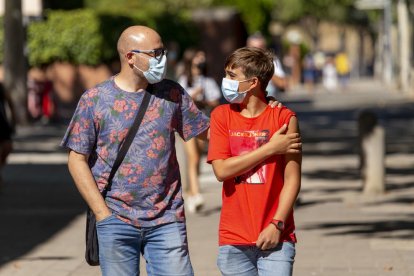 Pau Asensio, de 13 años, ayer con su padre después de recibir la vacuna en Lleida ciudad. 