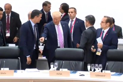 El moment en què Trump assenyala Sánchez el lloc on s’ha d’asseure a la taula del plenari.