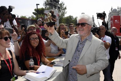 Pedro Almodóvar, ahir a la tarda exultant davant dels fans després de rebre el Lleó d’Or, i Scarlett Johansson, estrella a la catifa roja.