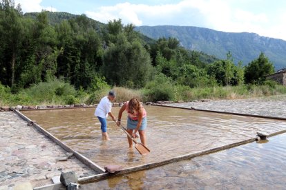 Dos persones treballant en una salina que encara funciona a Gerri de la Sal, al Pallars Sobirà.