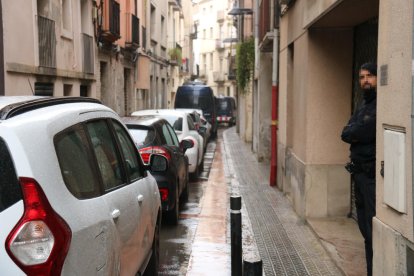 Un agent dels Mossos i dos furgones al carrer San Sebastià d'Igualada, on s'està escorcollant el domicili del detingut.