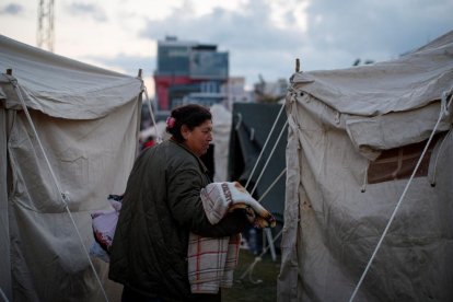 Una mujer camina entre las tiendas de un campamento.