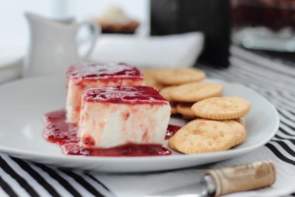 Tarta de queso con mermelada de fresa.