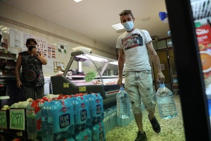 Un vecinos de Torres de Segre comprando garrafas para beber.