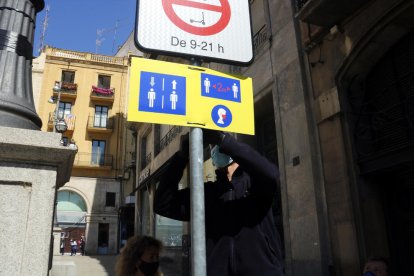 Un operario instala un cartel informativo en la plaza Sant Francesc.