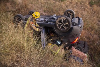 Bombers mentre revisaven ahir el vehicle accidentat a Tàrrega.