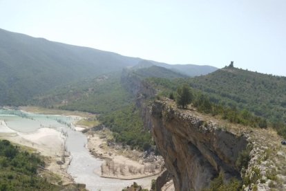 Vista del pendent amb les pedres a la carretera i al fons el riu Noguera Ribagorçana.