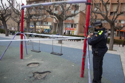 Un agent de la policia de Tàrrega precinta un parc infantil després de decretar-ho l’ajuntament.