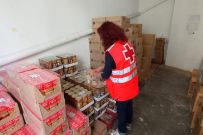 Una voluntària de Creu Roja Lleida, preparant els lots de menjar.