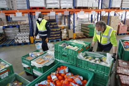 Voluntarios trabajando en la nave del Bancs dels Aliments de Lleida en el polígono Neoparc. 