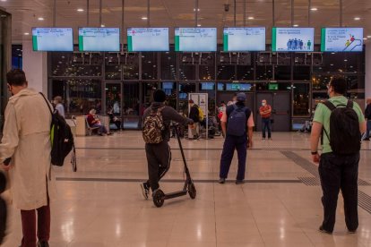 Diversos usuaris de Renfe esperen aquest matí al vestíbul de l'estació de Sants.