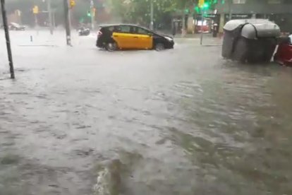 La avenida Paral·lel, inundada  -  El fuerte temporal de lluvias inundó ayer varias calles de Barcelona, como la avenida Paral·lel, donde el fuerte aguacero arrastró mobiliario urbano, como contenedores, además de provocar problemas de movilid ...